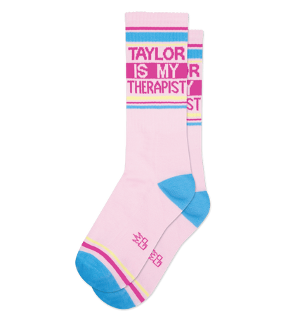 Alt text: Pink socks with light yellow accents read "Taylor is my therapist." Two pairs shown.