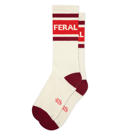 Natural cotton socks with cream accents. "FERAL" in red text on top. Red toe and heel detailing.